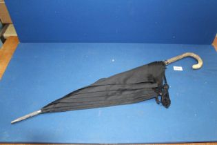 A black formal Umbrella having snake skin handle with sterling silver collar.