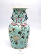 A large turquoise blue glazed Oriental vase having applied dragon and lizard decoration with floral