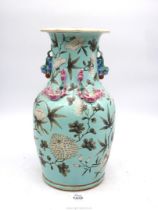 A large turquoise blue glazed Oriental vase having applied dragon and lizard decoration with floral