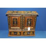 A black cabinet having painted floral decoration with two doors and two drawers,