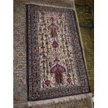 A border patterned and fringed rug in dark red on beige ground with jewel colours, 55'' x 28''.