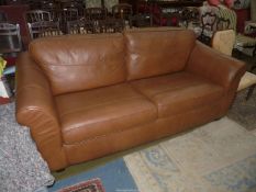 A two/three seater brown upholstered Settee.