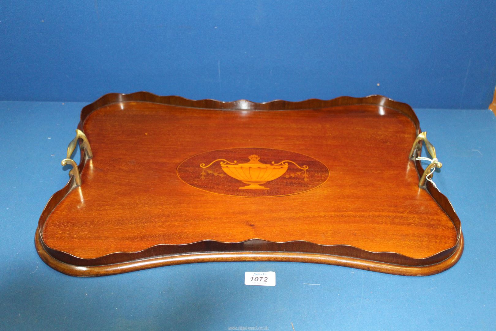 A 19th century Mahogany serpentine shape Butlers Tray with satinwood vase oval inlay to centre and