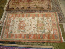 A Kabir pure wool hearth rug with borders of symbolic patterns in terracotta,