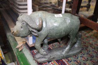 A carved green stone figure of a Buffalo, signed Zacharia Runyanga, 17" x 10 1/2".