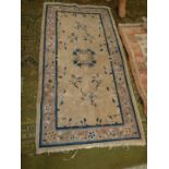 An Eastern style hearth rug with central gul in mixed beige shade and with blue/black border with