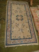An Eastern style hearth rug with central gul in mixed beige shade and with blue/black border with