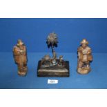 A pair of hand carved travelling men, 6" tall and a metal box surmounted by a palm tree,