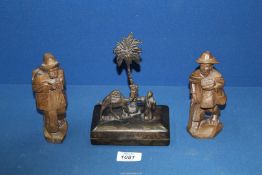 A pair of hand carved travelling men, 6" tall and a metal box surmounted by a palm tree,