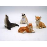 Four Lomonosov USSR animal figures including Racoon, Sea lion and two Lion Cubs.