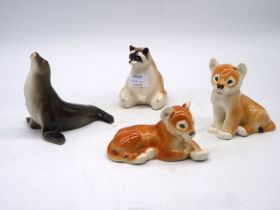 Four Lomonosov USSR animal figures including Racoon, Sea lion and two Lion Cubs.