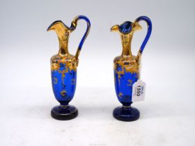 A pair of 19th century blue glass decorative Ewers with gilt and painted overlay, 8" tall.