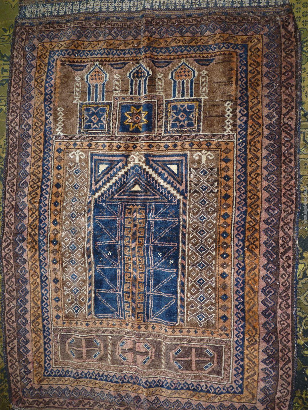 A Prayer rug in earth tones, brown and navy, 60'' x 35'' including fringe, some holes. - Image 2 of 4
