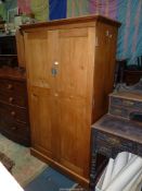 A mellow Pine double doored Cupboard/Wardrobe fitted internally with a hanging rail and later