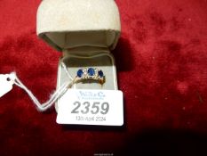 A ladies 14ct gold ring with three sapphires and four old cut diamonds.