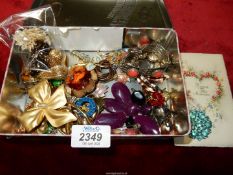 A tin containing costume jewellery including Lucite Brooch "Jelly Belly"