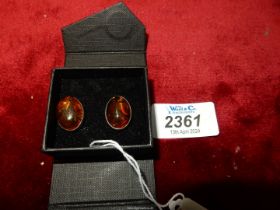 A pair of oval amber mounted in 925 silver clip-on earrings, 1/2" long.