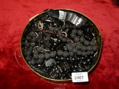 A tin of Jet and other black carved beads and necklaces (need re-stringing), etc.