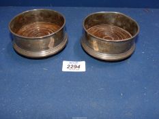 A pair of Birmingham Silver bottle coasters with wooden bases 1988 by Argil Silver, one dented.
