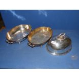 Two plated serving dishes on button feet and a food cover.