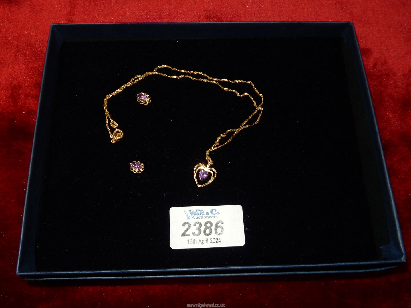 A 9ct gold chain with heart shaped pendant having purple stones,