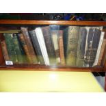 A small wooden bookcase with glass doors containing books to include Wayside and Woodland Trees,