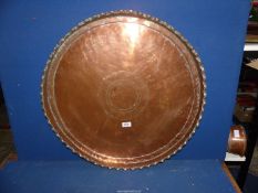 A large Copper tray having pie crust edge, 26" diameter.