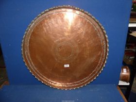 A large Copper tray having pie crust edge, 26" diameter.