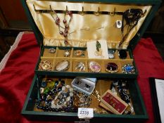 A box of costume jewellery in a green case.