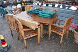 A teak patio Table and six chairs with pad cushions and parasol, 6' long x 39" high.