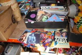 A box of LP's and a box of 45 rpm records including The Shadows, Paul Simon, Bonnie Tyler, etc.
