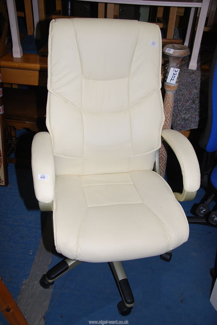 A cream coloured upholstered swivel office chair.