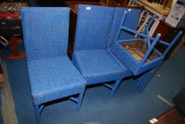 A set of four blue cane dining chairs.
