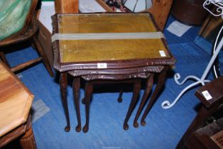 A nest of three leather topped tables