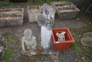 A buddah, angel and a lady with a sheath of corn.