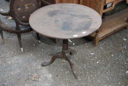 A circular Oak snap top table, 30" wide x 28" high.