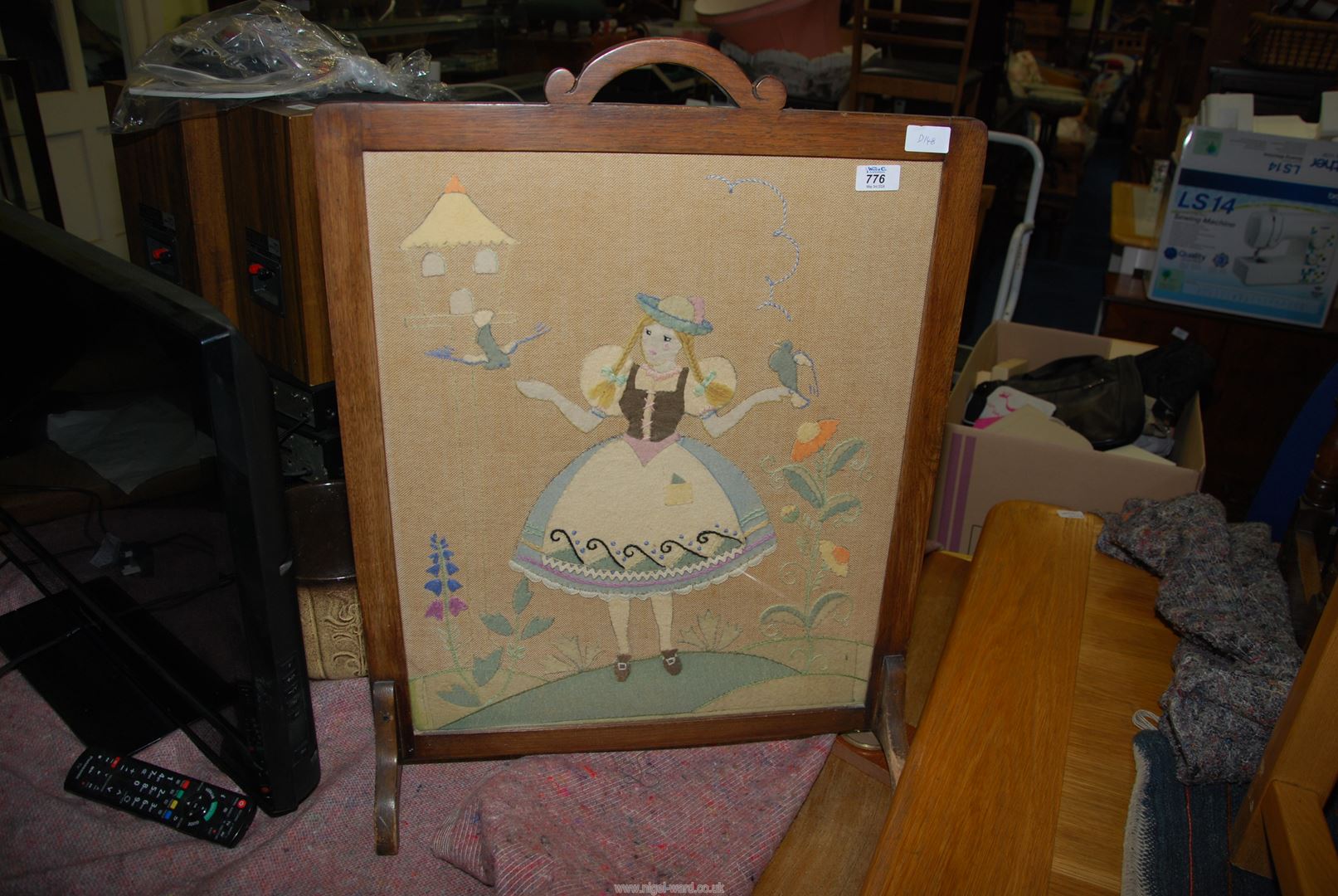 A fabric embroidered fire screen.