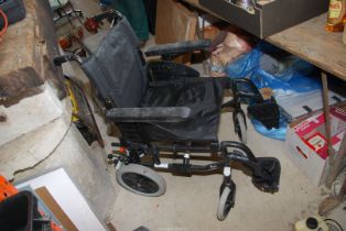 A small wheeled fold up mobility chair with foot rest.