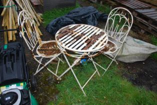 A metal bistro table, 24" diameter x 291/2" high and a pair of chairs.