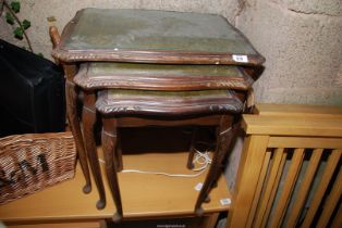 A nest of tables with leather tops and glass protectors.