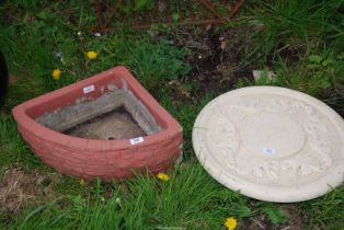 A corner concrete planter and a sundial top.