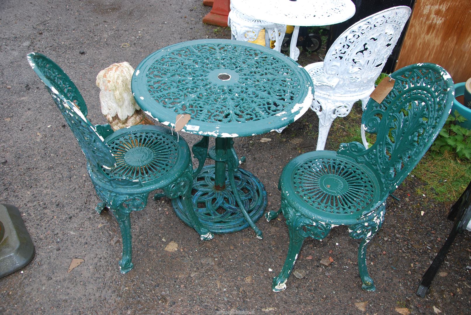 A circular Aluminium table and two chairs painted green, 27" high x 25 1/2" high.