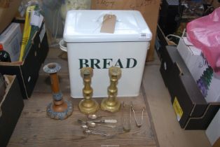 An enamel bread bin and brass candlesticks, teaspoons, sugar tongs etc.