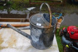 A large galvanized watering can.