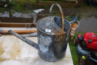 A large galvanized watering can.