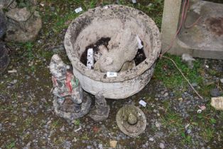 A circular planter with garden ornaments, a frog, etc.