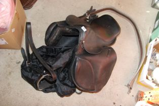 A large black leather Saddle with girth and stirrups.