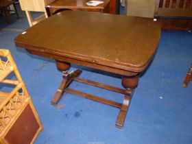 A drawleaf Oak finished top Table, 30'' x 42'' extending to 66'' x 30 1/2'' high.