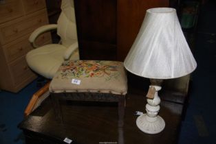 A small embroidered top stool and a lamp base.