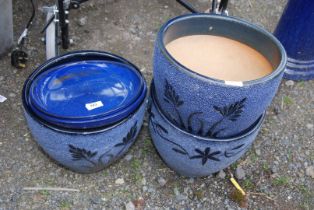 Three glazed planters with two saucers.